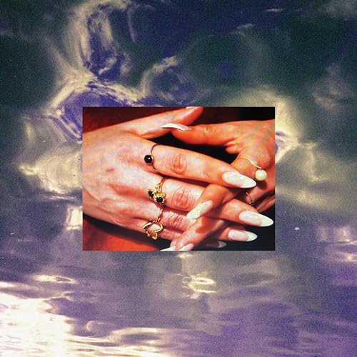 Hands with long nails and rings against a cloudy, textured background.