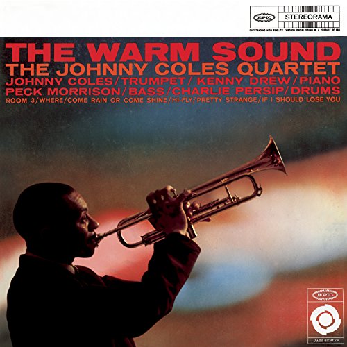 Silhouette of a man playing trumpet against a warm, colorful background.