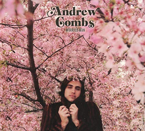"Album cover featuring a man in a dark coat standing beneath pink blossoms."