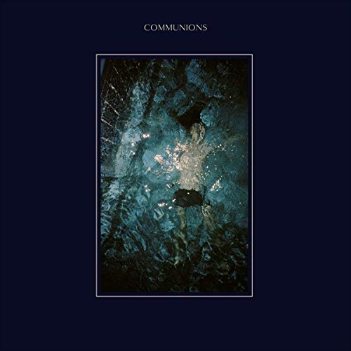 The image depicts a vinyl record cover for "Communions - Blue". The alt text is: "Dark blue album cover with abstract, shimmering blue and white center."