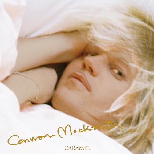 Close-up of a person with blonde hair, lying down, album cover.