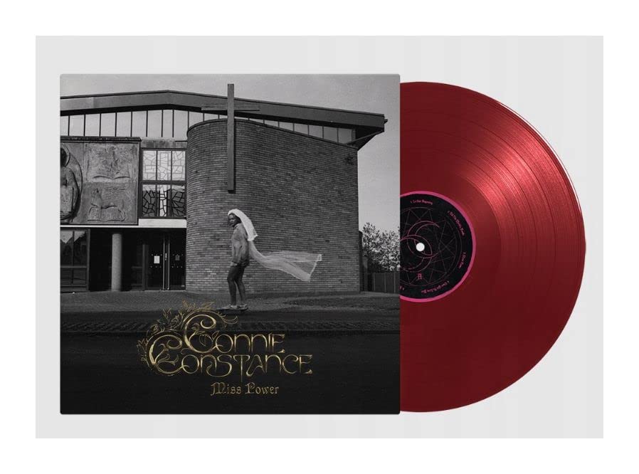 Vinyl record with album cover featuring a figure and building facade.