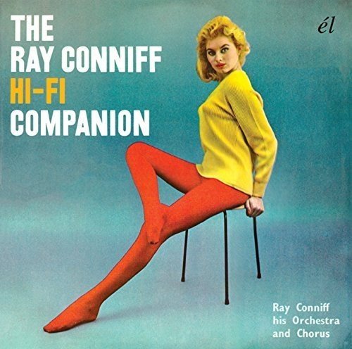 Blonde woman in yellow sweater and red tights sits on a stool, album cover.