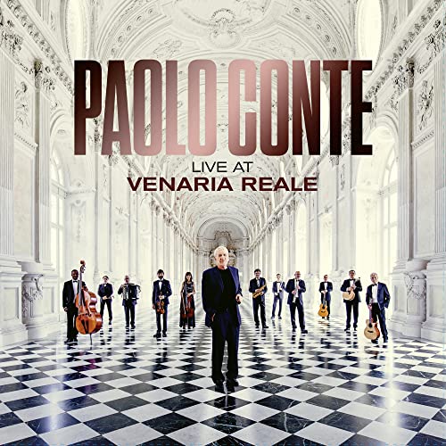 Paolo Conte and band posing in a grand, ornate hall.