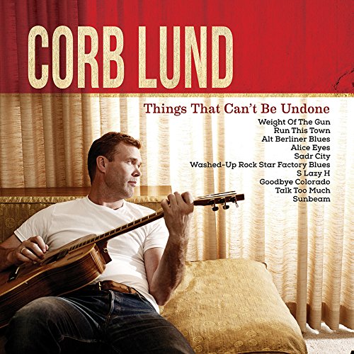 "CD cover featuring Corb Lund holding a guitar, sitting on a couch."