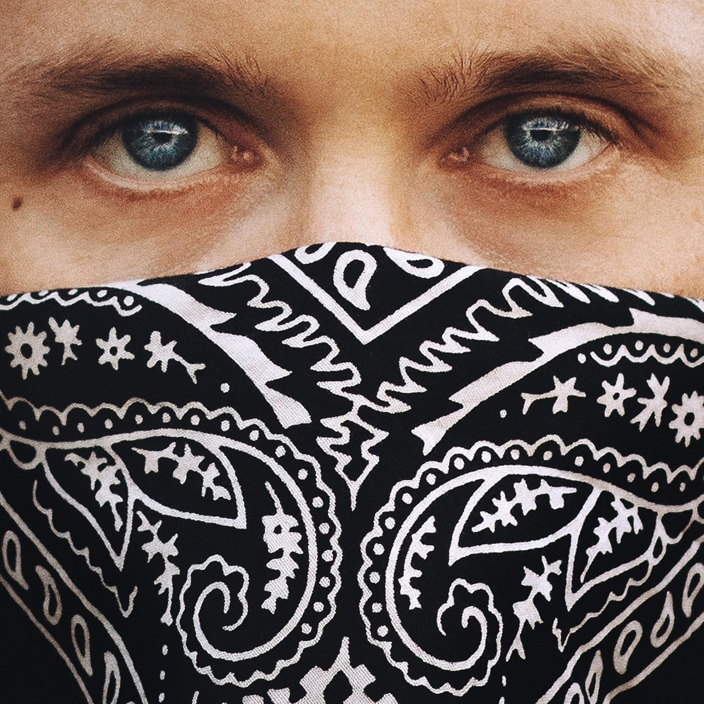 Close-up of a man with blue eyes wearing a black bandana.