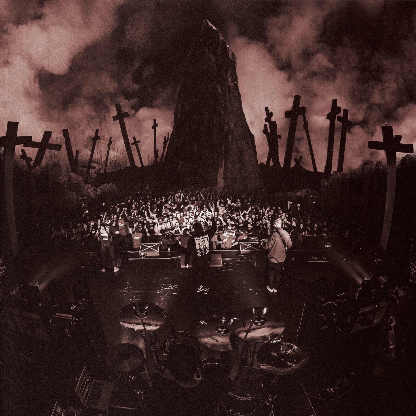 Band performing on stage with a backdrop of a graveyard.