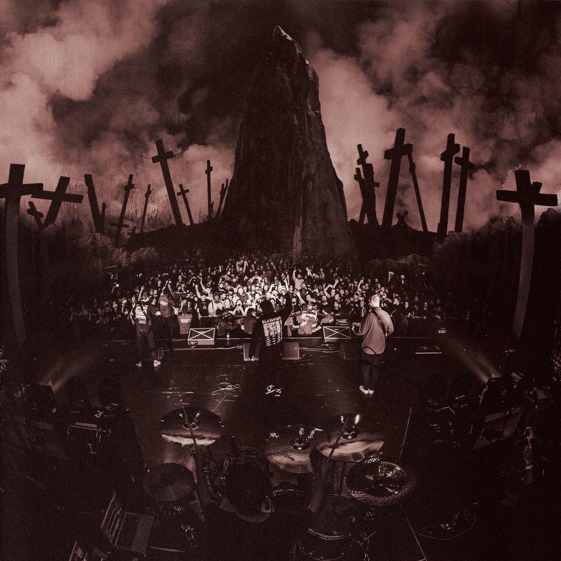 Band performing on stage with a backdrop of a graveyard.