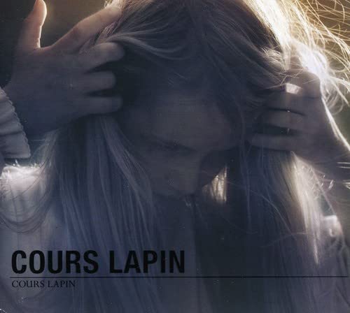 CD cover with a person’s face obscured by long hair and hands.