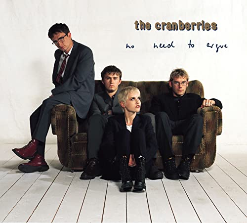 The Cranberries band members seated on a brown couch, album cover.