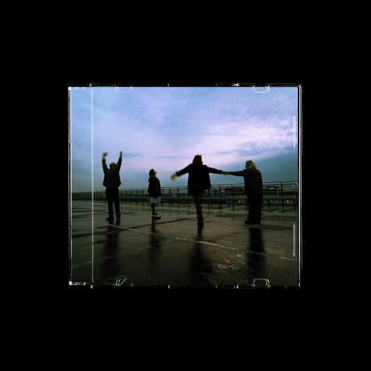 CD cover: Four figures silhouetted on a wet rooftop under a cloudy sky.
