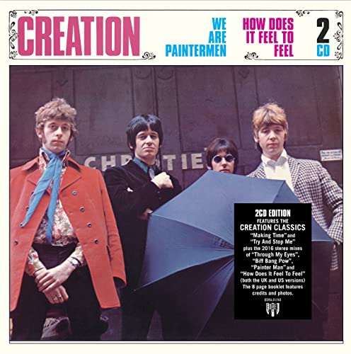 Four men from the band The Creation pose together, one holding a large umbrella.