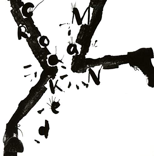 The image depicts a black-and-white album cover featuring the word "ROCKMAN" shattered across three branches.