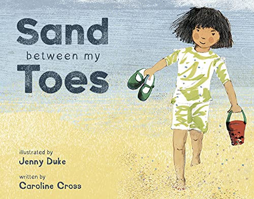 Child walking on beach holding sandals and a red bucket.
