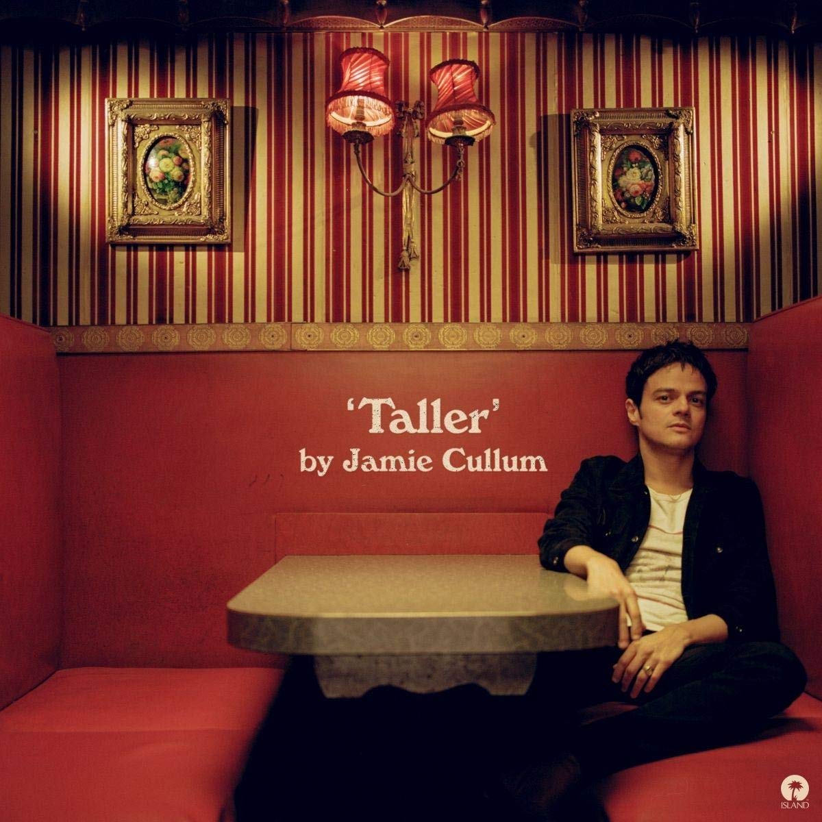 Jamie Cullum sits alone at a table in a red, vintage-style diner booth.