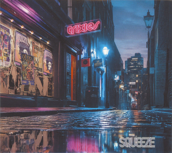 Wet city street at night with neon signs and building reflections.