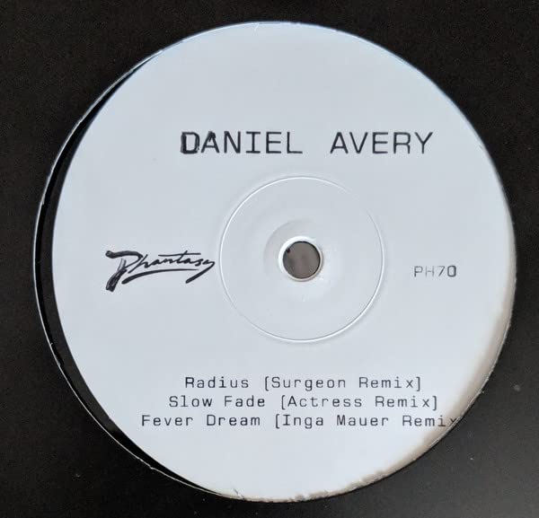 White vinyl record label with black text: “Daniel Avery – Slow Fade Remixes.”