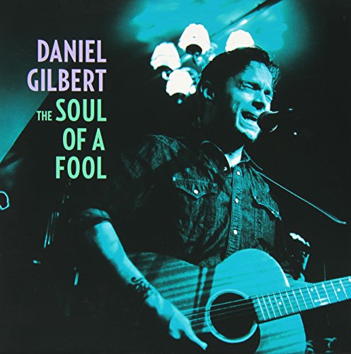 Daniel Gilbert playing acoustic guitar, album cover with blue text.