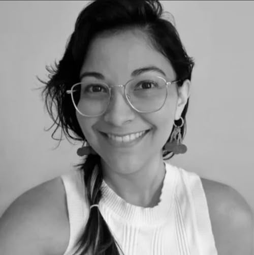 Black and white portrait of a smiling woman wearing glasses.