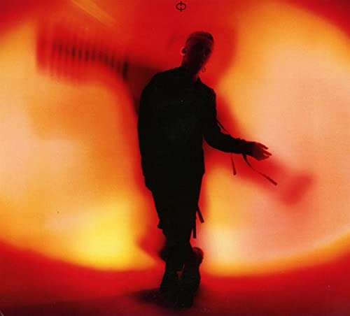 Silhouetted figure against a blurred, fiery orange and red background.