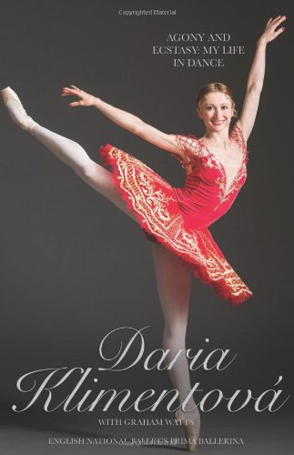 Ballerina in a red dress posing on one leg against a dark background.