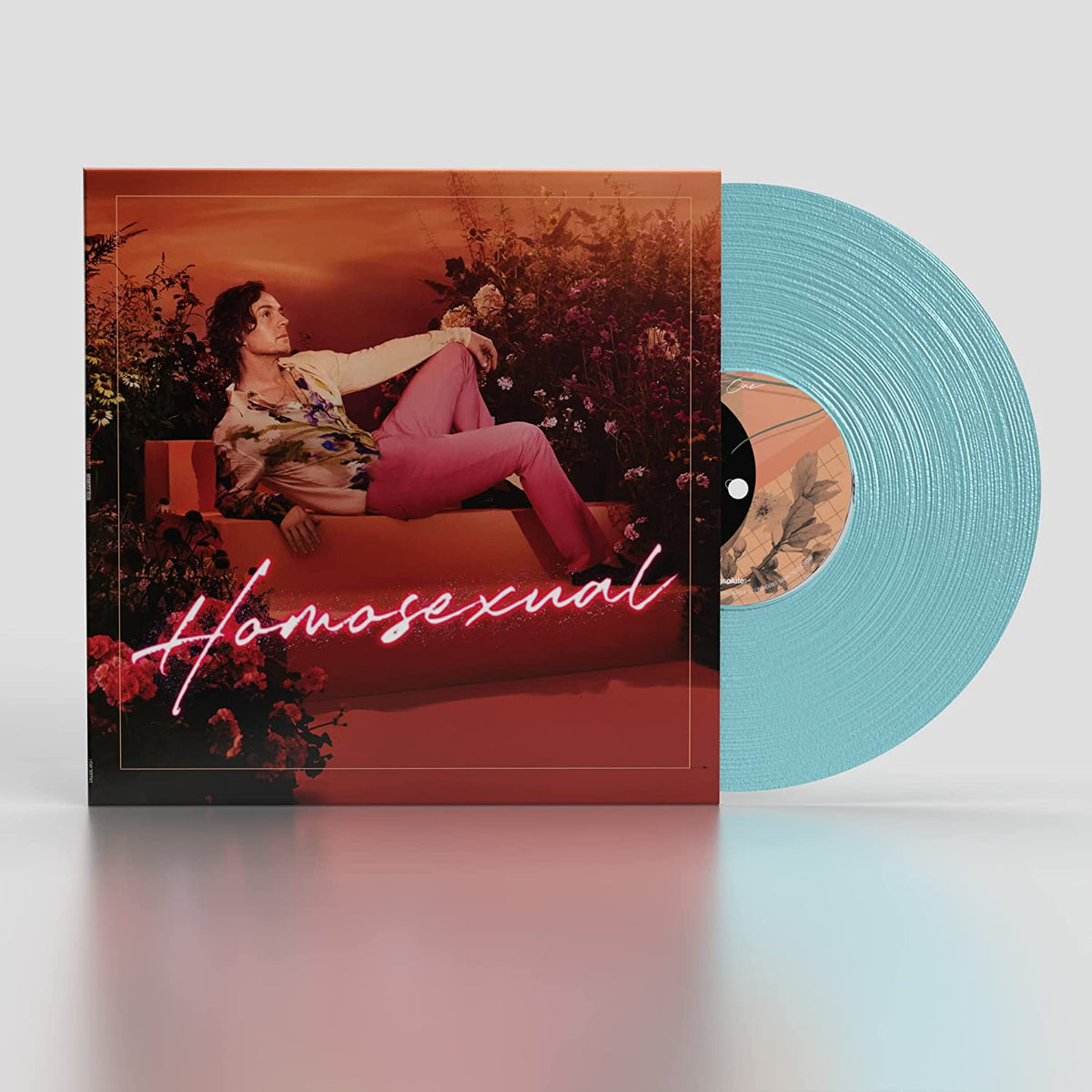 Vinyl record with light blue disc and album cover featuring a man surrounded by flowers.