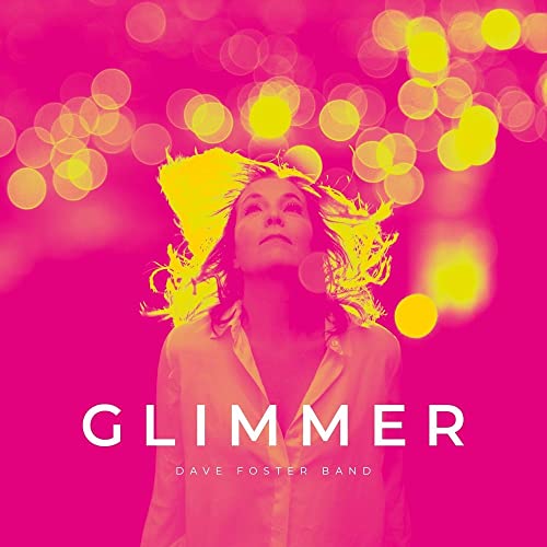 A woman looks upward against a bright pink background with yellow bokeh light circles.