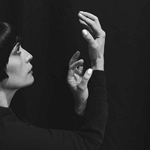 Black and white portrait of a woman with raised hands.