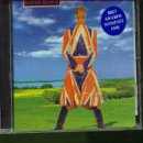 David Bowie in a colorful Union Jack suit, standing in a field.