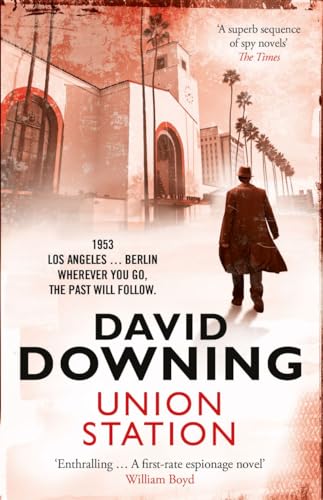 A man in a trench coat walks toward a train station in this book cover.