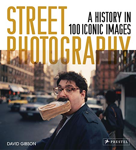 Book cover featuring a man holding a book in his mouth on a street.