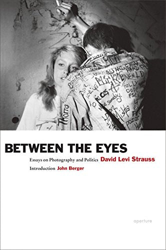 Book cover with black and white photo of people embracing, graffiti wall.