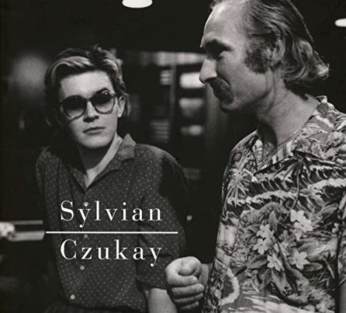 Black and white portrait of David Sylvian and Holger Czukay.