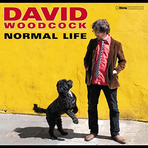 CD cover: David Woodcock with a black dog on yellow background.