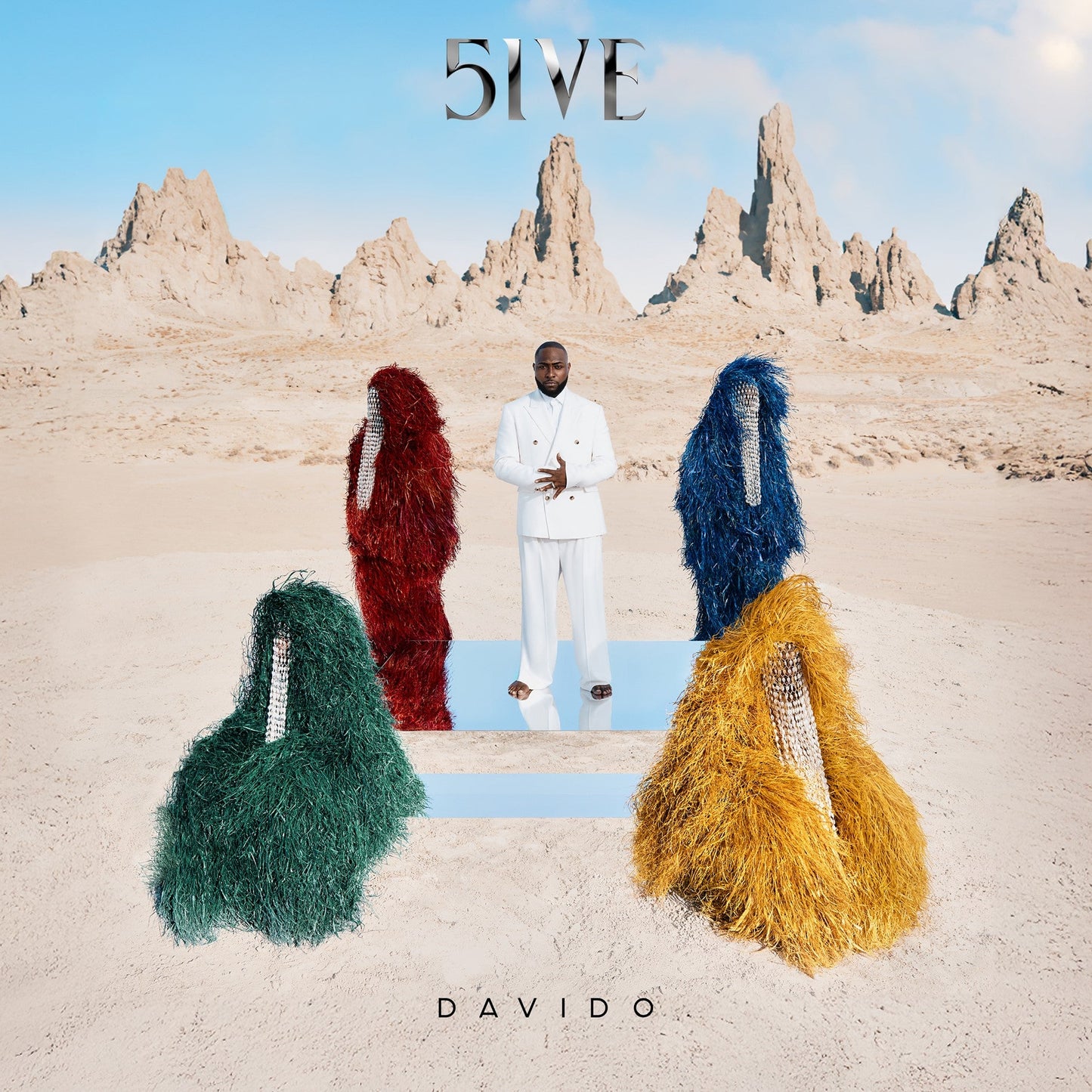 Man in white suit surrounded by four colorful shaggy figures in a desert landscape.