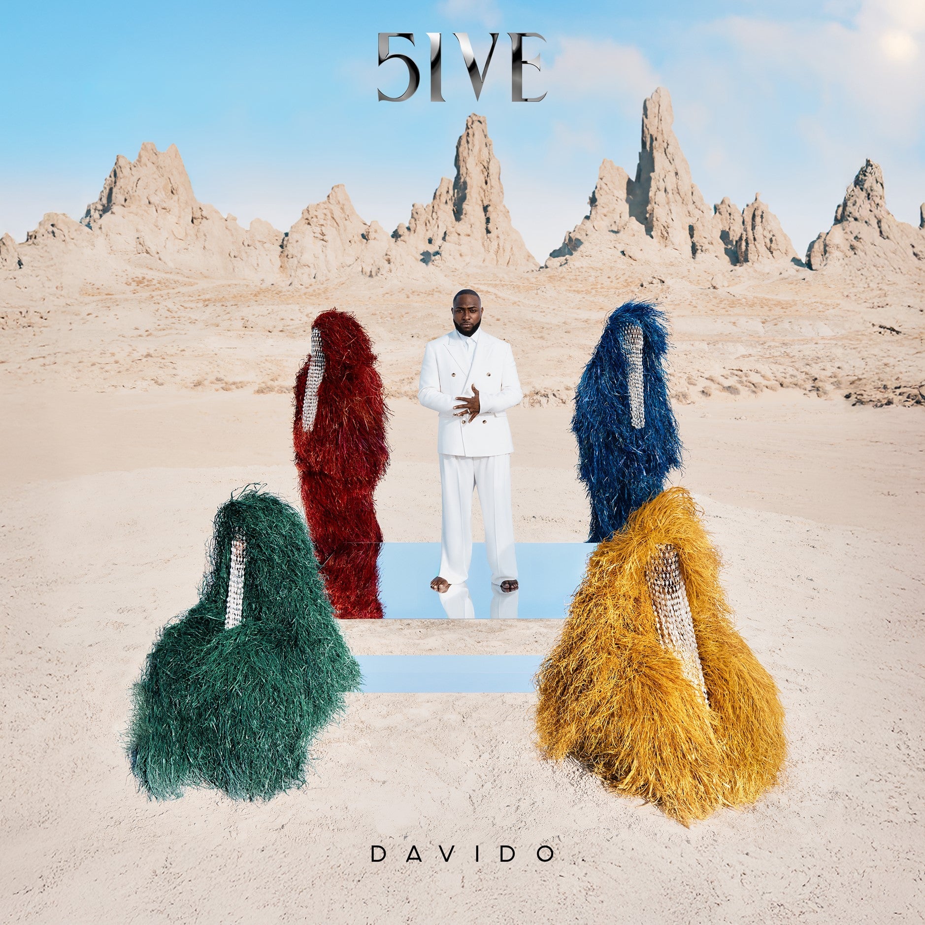 Man in white suit surrounded by four colorful shaggy figures in a desert landscape.