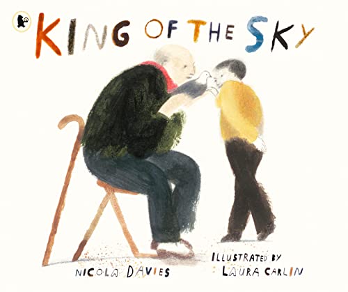 An old man sitting on a chair holds a pigeon while a boy watches.