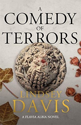 Book cover: “A Comedy of Terrors” with a carved stone face and autumn leaves.