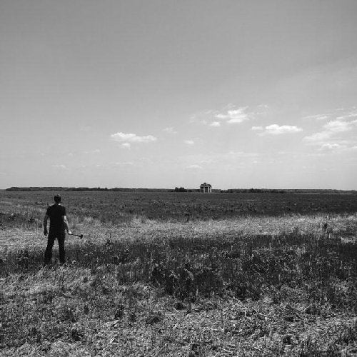 Black and white album cover with a lone figure in a field.