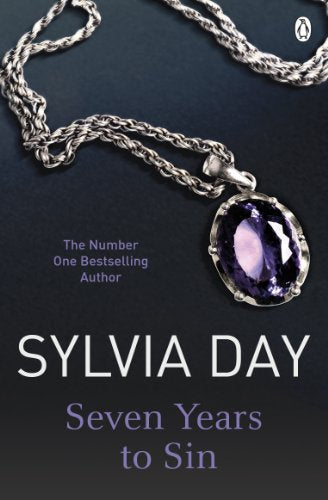 A silver necklace with a large purple gemstone on a dark background.