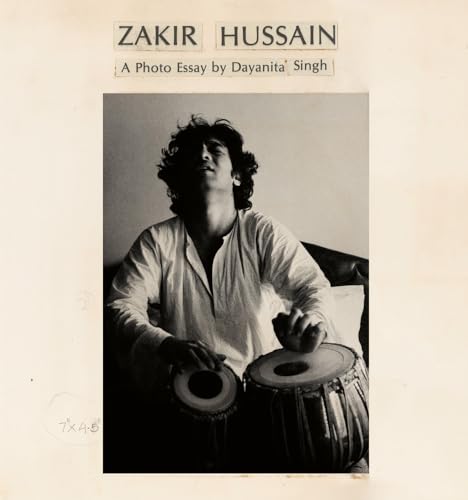Black and white portrait of Zakir Hussain playing the tabla.