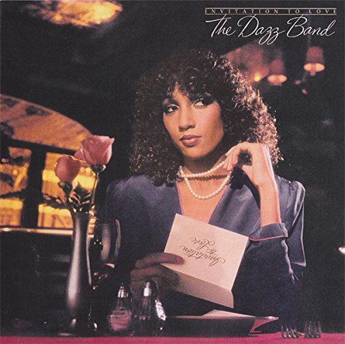 Album cover featuring a woman holding a card, with a rose and vase nearby.