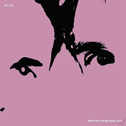 A pink album cover with a black abstract face and white text.