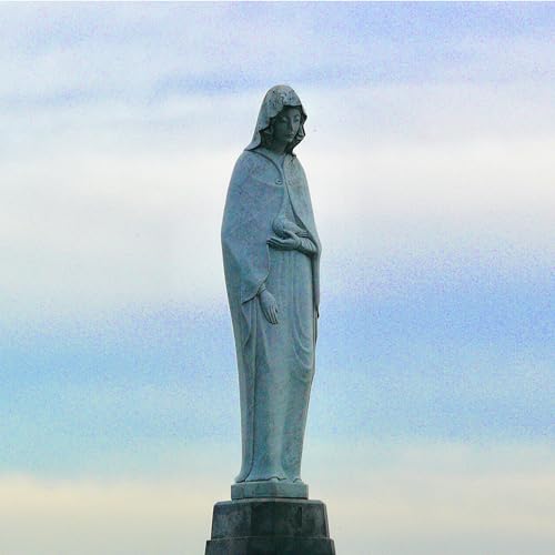 Stone statue of a cloaked figure with hands clasped in prayer.
