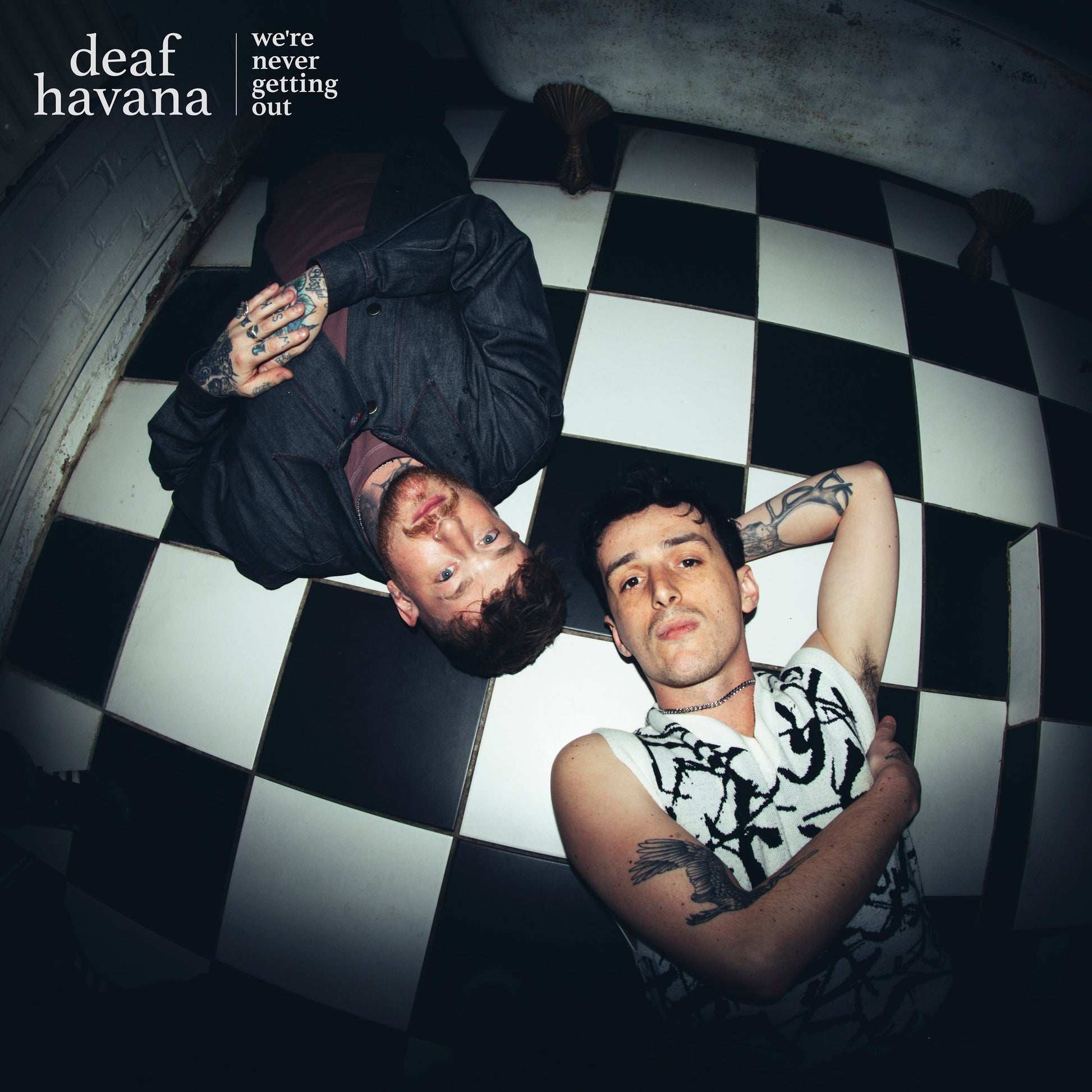 Album cover: two men lying on a checkered floor, close-up.
