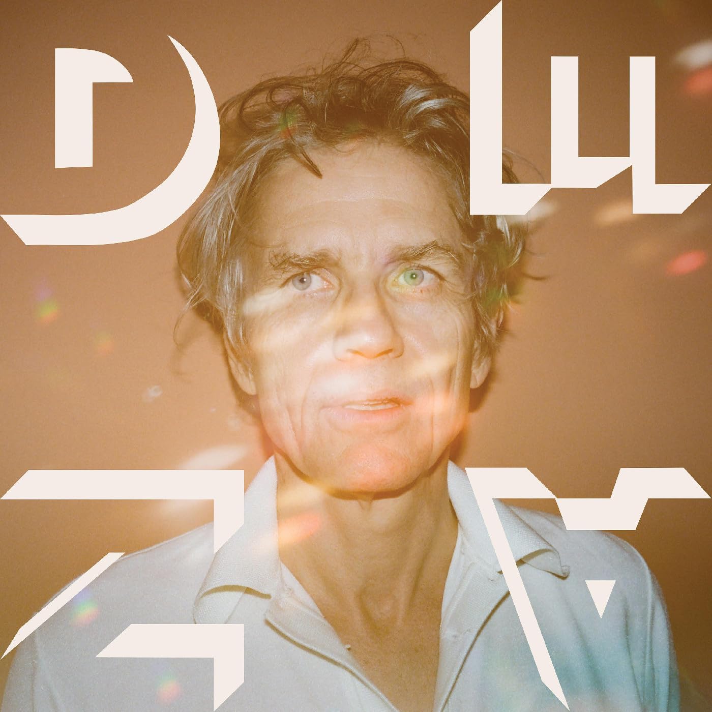 CloseCandid portrait of Dean Wareham with abstract white geometric shapes overlaying the image.