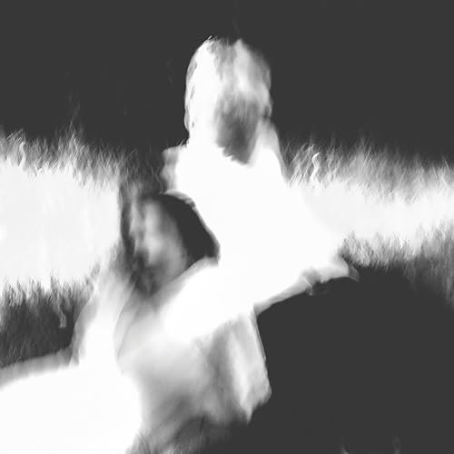 Black and white abstract image of blurred figures in grass.