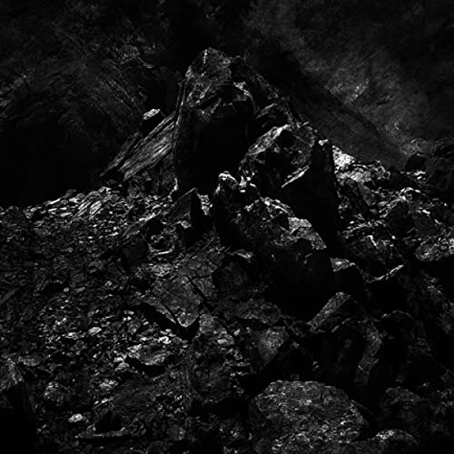 Dark, jagged mountain peak against a smoky, black sky.
