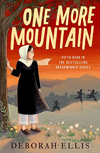 A girl in a headscarf stands by a tree against a mountain sunset background.