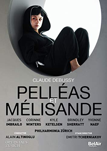A person in a black hoodie sits in a circular frame above opera text.